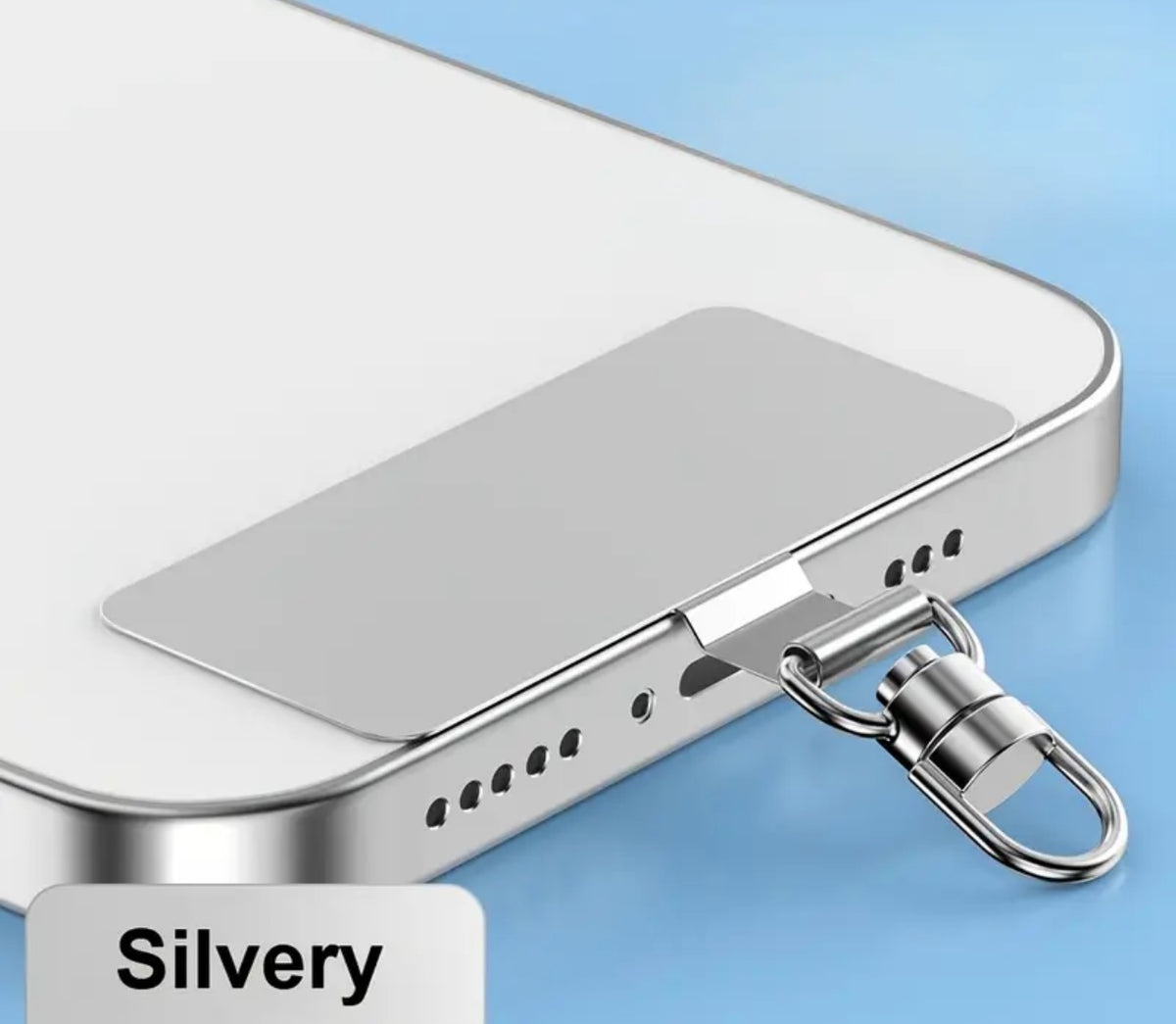 A close-up of a silver metal lanyard insert accessory attached to the bottom edge of a white smartphone, with a label reading 'Silvery' in the lower left corner, set against a light blue background.