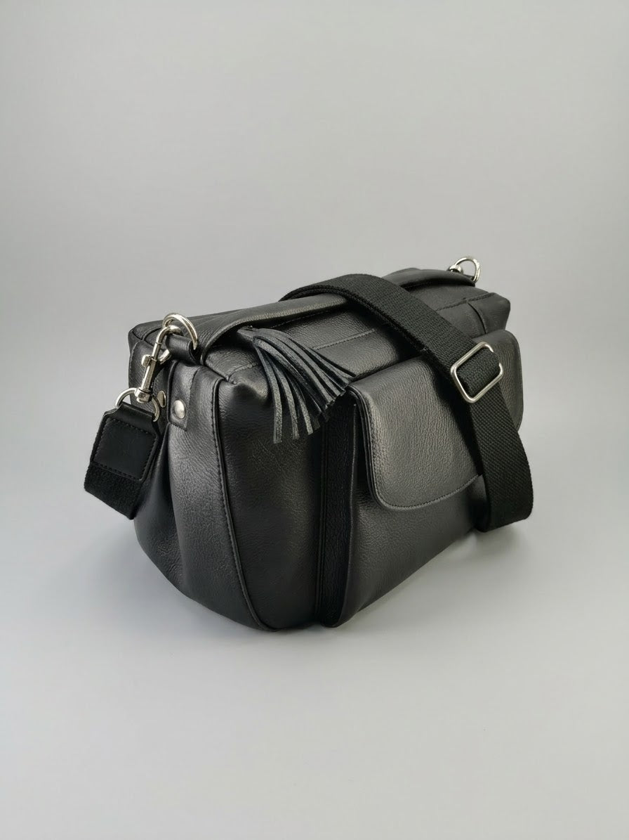 Stile' Nora black leather crossbody bag — side angle showing structured depth and leather tassel detail